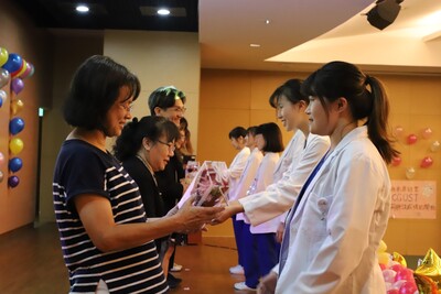 16~加袍生代表送花給老師，感謝老師平日教誨圖片
